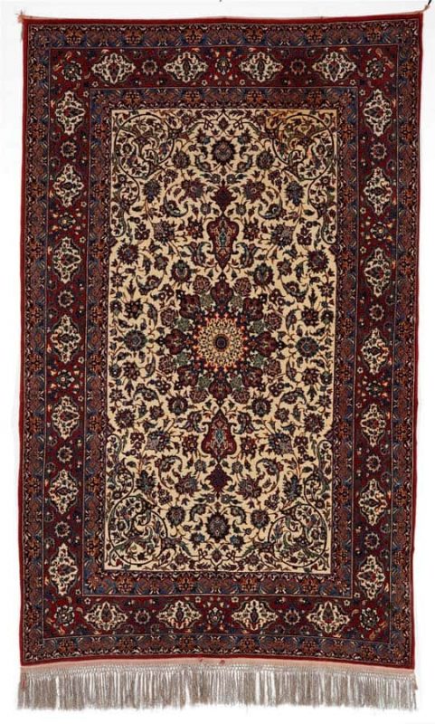 A Isfahan rug, Persia. Medallion design on an ivory field. Knotted on silk warps. C. 1960. C. 800.000 kn. pr. sqm. 244 x 149 cm. Estimation euro 1300.