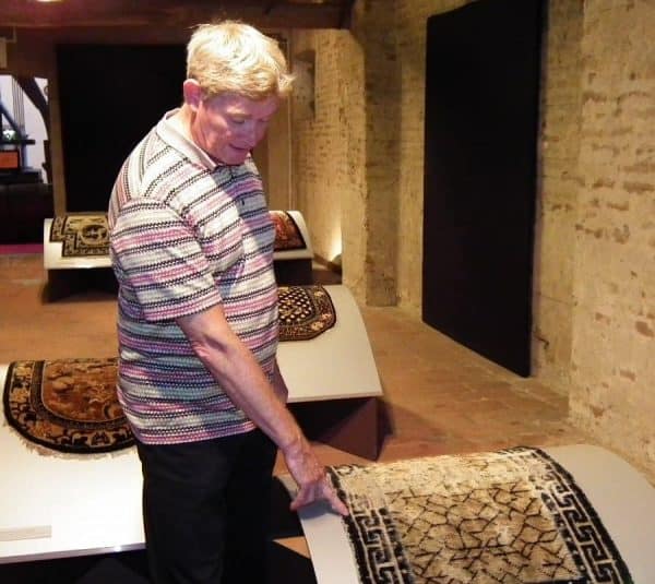 Koos de Jong pointing out details in a saddle rug.